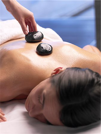 Hot stone massage / woman on a massage table Fotografie stock - Premium Royalty-Free, Codice: 689-03127318