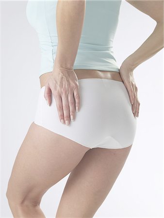 female body waist - Woman wearing white underwear,detail of waist and backside Stock Photo - Premium Royalty-Free, Code: 689-03127538