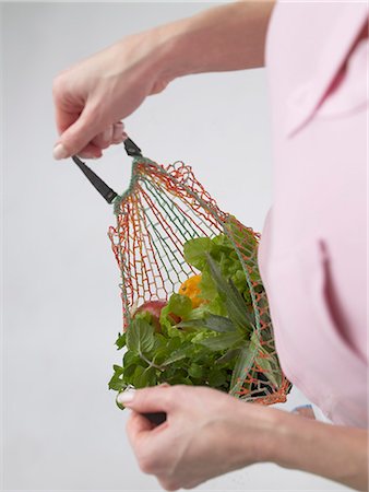 Woman with fruit and vegetables in a string bag Stock Photo - Premium Royalty-Free, Code: 689-03127575