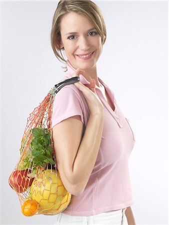Woman with fruit and vegetables in a string bag Stock Photo - Premium Royalty-Free, Code: 689-03127571