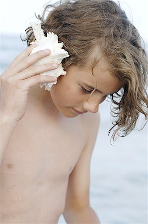 Boy at the sea with a mussel Stock Photo - Premium Royalty-Free, Code: 689-03129494