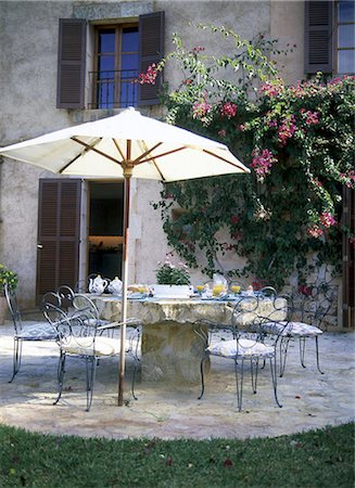 Breakfast table on the terrace with parasol Stock Photo - Premium Royalty-Free, Code: 689-03129870