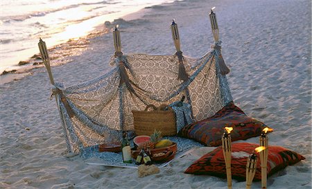 floor cushion - Twilight on the beach: windbreak and torches Stock Photo - Premium Royalty-Free, Code: 689-03123707