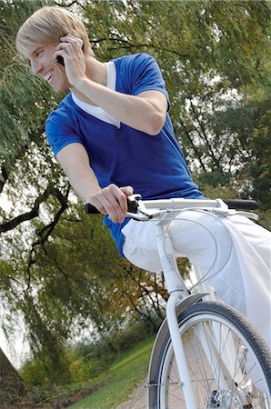 Blonde man with mobile and bicycle Foto de stock - Royalty Free Premium, Número: 689-03130931