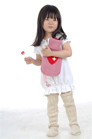 Girl holding lollipop and hot-water bag Stock Photo - Premium Royalty-Free, Code: 689-03733142