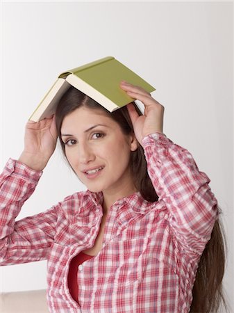 feeling safe - Woman holding book above her head Stock Photo - Premium Royalty-Free, Code: 689-03733182