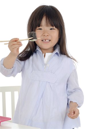 Girl eating sushi Stock Photo - Premium Royalty-Free, Code: 689-03733202