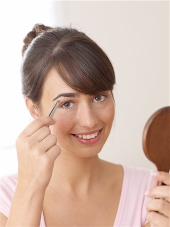 Woman plucking eyebrow Stock Photo - Premium Royalty-Free, Code: 689-03733589