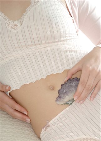 stomach hands - Woman holding rock crystal on her stomach Stock Photo - Premium Royalty-Free, Code: 689-03733636