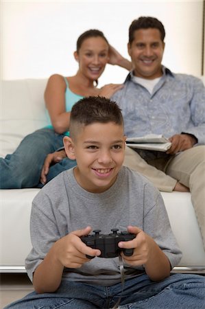 simsearch:632-02744860,k - Parents regarder fils jouer de jeux de vidéo dans le salon, vue de face Photographie de stock - Premium Libres de Droits, Code: 694-03318039