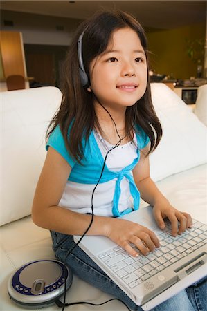 simsearch:694-03329116,k - Girl sitting on sofa Using Laptop and Listening to Music Foto de stock - Sin royalties Premium, Código: 694-03318063