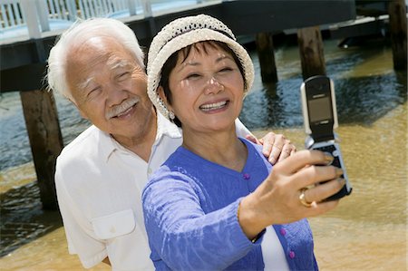 fun phone dock - Senior couple photographing themselves by pier Stock Photo - Premium Royalty-Free, Code: 694-03318225