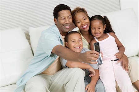 simsearch:693-03564963,k - Famille prenant photo de famille sur le canapé avec le téléphone appareil photo Photographie de stock - Premium Libres de Droits, Code: 694-03318508