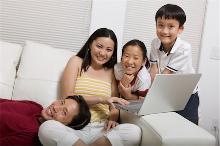 Family on Couch Using Laptop, portrait Stock Photo - Premium Royalty-Free, Code: 694-03318532