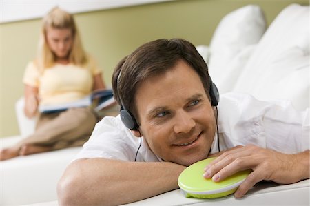 discman - Mann, die Musik zu hören, während Frau liest Stockbilder - Premium RF Lizenzfrei, Bildnummer: 694-03318559