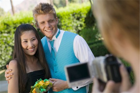 simsearch:694-03318741,k - Well-dressed teenager couple posing for video camera outside school dance Fotografie stock - Premium Royalty-Free, Codice: 694-03318760