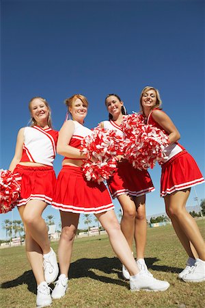 simsearch:693-03299836,k - Cheerleaders with Pom-poms standing on football field, low angle view, portrait, (portrait), (low angle view) Stock Photo - Premium Royalty-Free, Code: 694-03319105