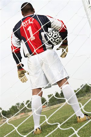 soccer goalkeeper backside - Goalkeeper standing in goal with ball, back view Stock Photo - Premium Royalty-Free, Code: 694-03319179