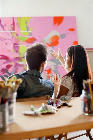 Couple discussing  painting in artist's studio, back view Stock Photo - Premium Royalty-Free, Code: 694-03325335