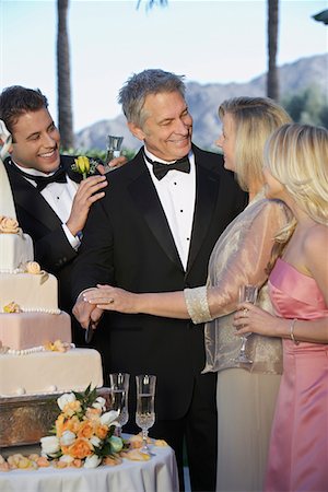 Couple d'âge mûr avec un jeune homme et une femme étaient rassemblés près de gâteau de mariage Photographie de stock - Premium Libres de Droits, Code: 694-03326847
