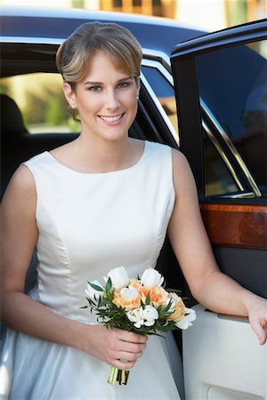 Young woman holding bouquet in open door of limousine, portrait Stock Photo - Premium Royalty-Free, Code: 694-03326867