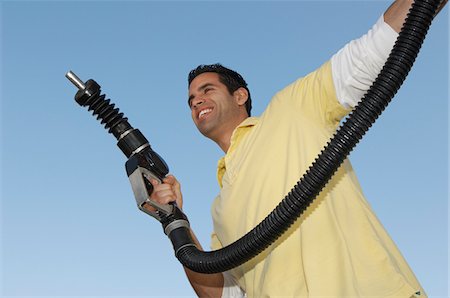 pictures of people at gas station - Man holding fuel pump Stock Photo - Premium Royalty-Free, Code: 694-03326889