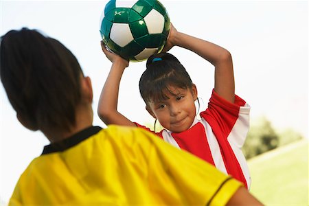 Girl soccer player (7-9 years) preparing to throw ball Stock Photo - Premium Royalty-Free, Code: 694-03327057