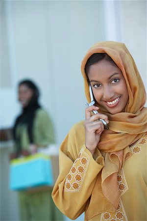 Two muslim woman, one talking on mobile phone Stock Photo - Premium Royalty-Free, Code: 694-03327100