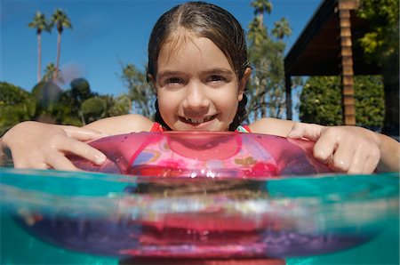 Girl with inflatable raft in swimming pool Stock Photo - Premium Royalty-Free, Code: 694-03327198