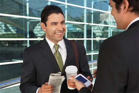 Two businessmen with take away coffee, newspaper, and PDA, outdoors Stock Photo - Premium Royalty-Free, Code: 694-03327757