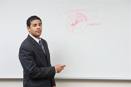 Business man giving presentation standing at whiteboard Stock Photo - Premium Royalty-Free, Code: 694-03327887
