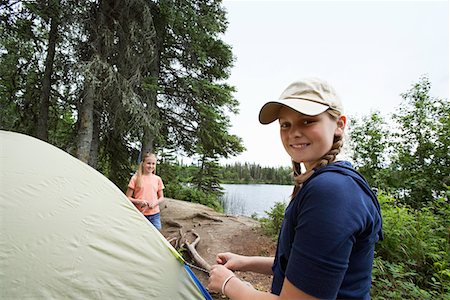 Two teenage girls standing by tent near lake, portrait Stock Photo - Premium Royalty-Free, Code: 694-03328104