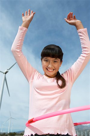 Girl (7-9) playing with hula hoop at wind farm, portrait Stock Photo - Premium Royalty-Free, Code: 694-03328184