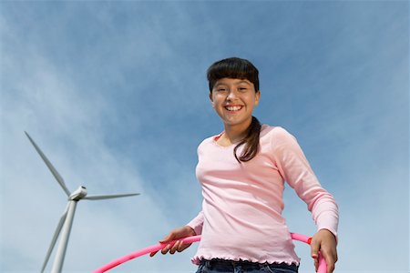 Girl (7-9) holding hula hoop at wind farm, portrait Stock Photo - Premium Royalty-Free, Code: 694-03328183