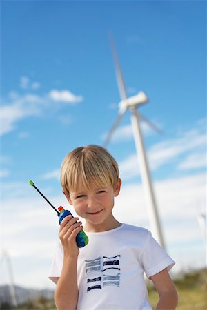 Boy (7-9) holding toy walky-talky at wind farm, portrait Stock Photo - Premium Royalty-Free, Code: 694-03328212