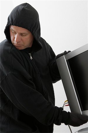 Burglar stealing television set Fotografie stock - Premium Royalty-Free, Codice: 694-03328269