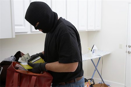 Burglar stealing money from house, close-up Foto de stock - Royalty Free Premium, Número: 694-03328277