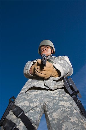 soldier standing with gun - Portrait of soldier aiming to camera Stock Photo - Premium Royalty-Free, Code: 694-03328397