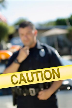 enforcement - Police Officer Standing Behind Police Tape Stock Photo - Premium Royalty-Free, Code: 694-03328433