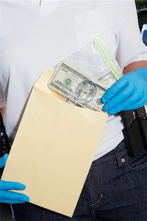 Officier de police, mettre de l'argent dans l'enveloppe de preuve Photographie de stock - Premium Libres de Droits, Code: 694-03328471