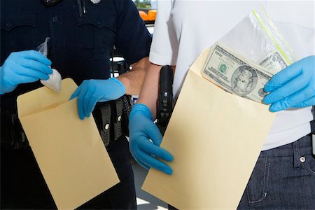 Officier de police, mettre de l'argent dans l'enveloppe de preuve Photographie de stock - Premium Libres de Droits, Code: 694-03328472