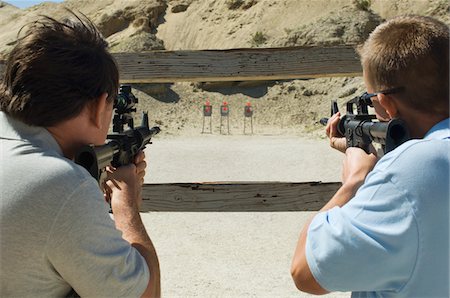 simsearch:694-03328608,k - Men aiming rifles at firing range Foto de stock - Royalty Free Premium, Número: 694-03328578