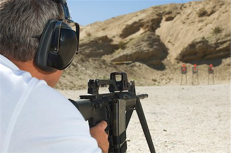 Man aiming machine gun at firing range Foto de stock - Sin royalties Premium, Código: 694-03328593