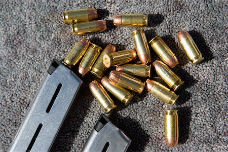 Gun magazine and bullets on carpet, close-up Stock Photo - Premium Royalty-Free, Code: 694-03328635