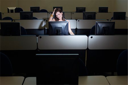 frustrated school students in classroom - Female student with hand on head in computer classroom Stock Photo - Premium Royalty-Free, Code: 694-03328820