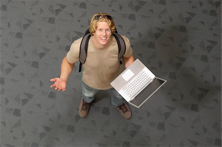 Male student holding laptop, indoors, portrait Stock Photo - Premium Royalty-Free, Code: 694-03328836