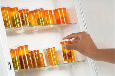 pill bottle in hand - Persons hand taking pill bottle from shelf Stock Photo - Premium Royalty-Free, Code: 694-03329014