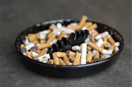 Full ashtray of cigarettes on table, close-up Foto de stock - Sin royalties Premium, Código: 694-03329027