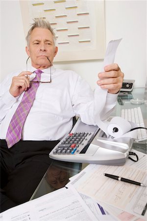 recibir - Businessman Looking at Calculator Paper Foto de stock - Sin royalties Premium, Código: 694-03329358