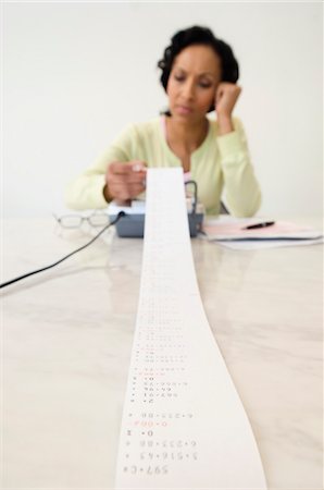 Woman Reading Adding Machine Tape Stock Photo - Premium Royalty-Free, Code: 694-03329398